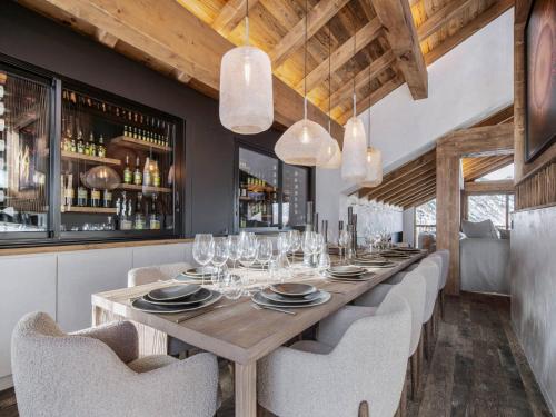 une salle à manger avec une longue table et des chaises dans l'établissement Chalet spacieux avec bain nordique, hammam et vue proche des pistes - FR-1-570-66, à Saint-Martin-de-Belleville