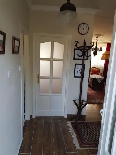a hallway with a door and a clock on the wall at Kussbach apartman in Sárospatak