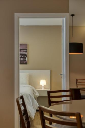 a bedroom with a bed and a table and chairs at Palazzo Torquetti in Belo Horizonte