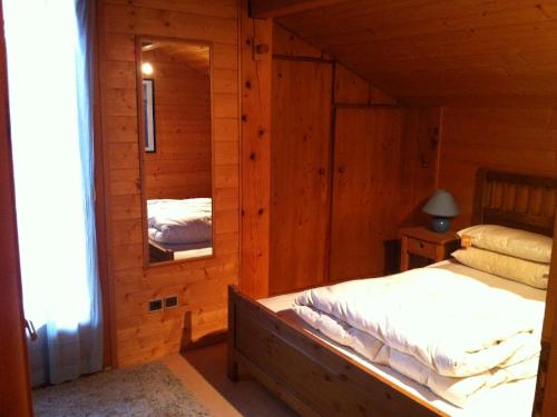 une chambre avec un lit dans une cabane en bois dans l'établissement Chalet familial avec Wifi et parking aux Gets - FR-1-671-280, aux Gets