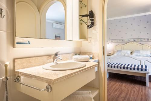 a bathroom with a sink and a bed at Doce Canela - Pousada de Charme in Canela