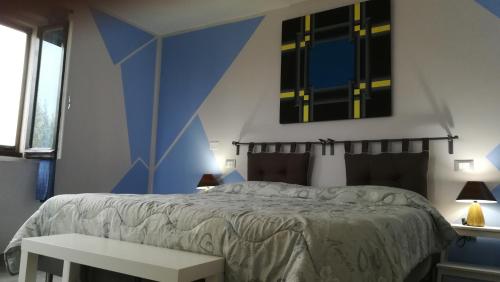 a bedroom with a bed with a blue wall at Sotto l'Ulivo in Mondavio
