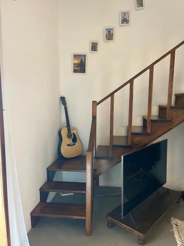 a staircase with a television and a guitar in a room at Casa Serena in Filicudi