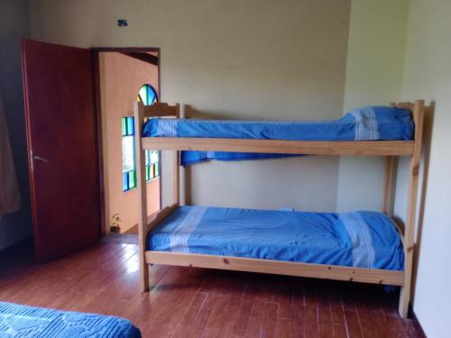 two bunk beds with blue sheets in a room at Dimensión moonlight in La Falda