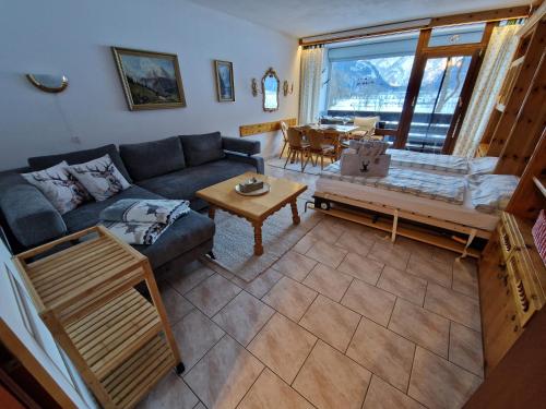 uma sala de estar com um sofá e uma mesa em Alpenliebe Lofer - Bergblick & Pool em Sankt Martin bei Lofer