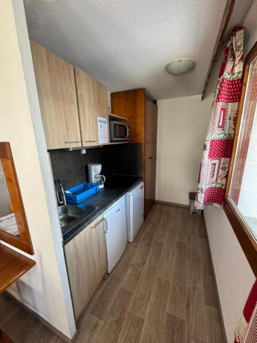 une petite cuisine avec un évier et un micro-ondes dans l'établissement Val Set, à Val Thorens