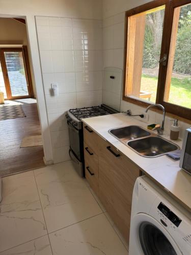 a small kitchen with a sink and a stove at Casa a metros del lago Gutiérrez in San Carlos de Bariloche