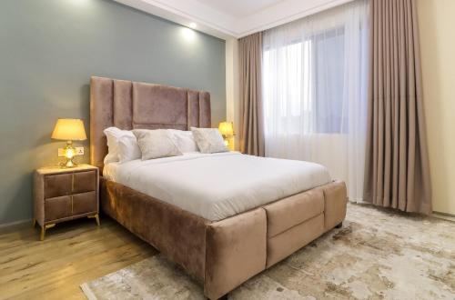a bedroom with a large bed and a window at 2 BR Condo with a balcony, pool&gym in Nairobi