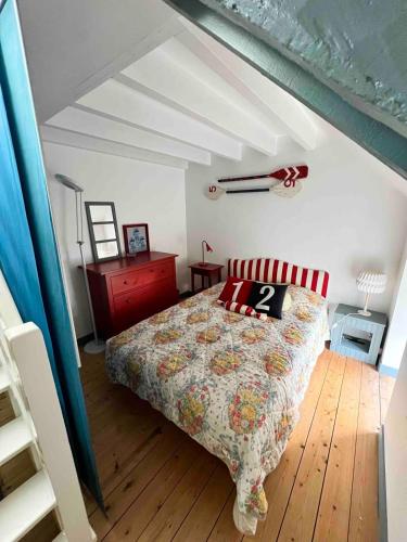 une chambre avec un lit dans un grenier dans l'établissement Maison de famille en bord de mer, à Saint-Gildas-de-Rhuys