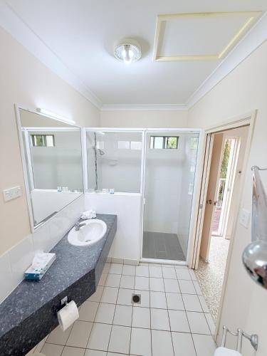 a bathroom with a sink and a shower at Emu Park Beach Resort in Emu Park