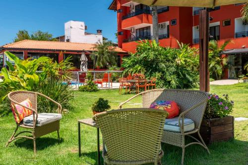 three chairs and a table in a yard at Rizzu Marina Hotel in Balneário Camboriú
