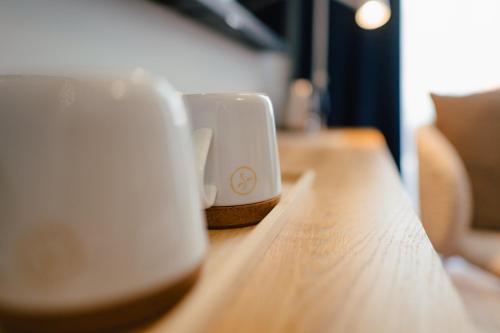 two coffee cups sitting on top of a wooden table at The Layhead B&B in Lübeck
