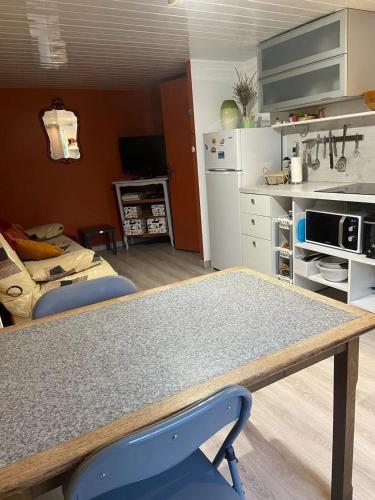 une cuisine avec une table et une chaise bleue dans l'établissement Appartement rénové à Lapte avec terrasse 40 m², à Lapte