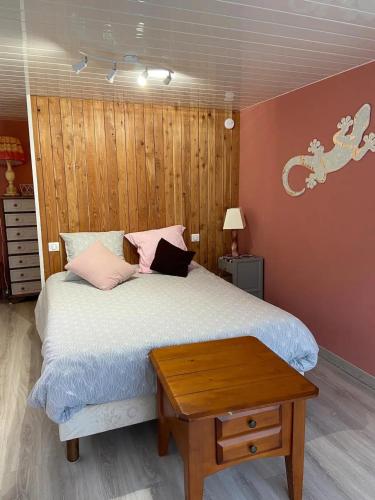 - une chambre avec un lit doté d'oreillers roses et d'une table dans l'établissement Appartement rénové à Lapte avec terrasse 40 m², à Lapte