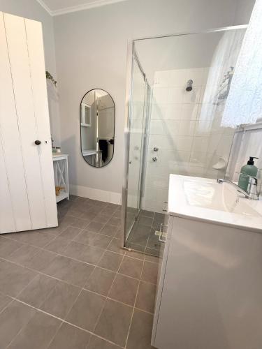 a bathroom with a shower and a sink and a mirror at Clare Cottage with 3 King Suites in Clare