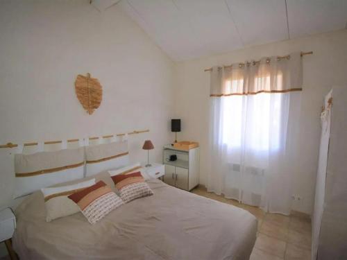 a white bedroom with a large bed and a window at Maison familiale spacieuse avec piscine à Vagnas in Vagnas