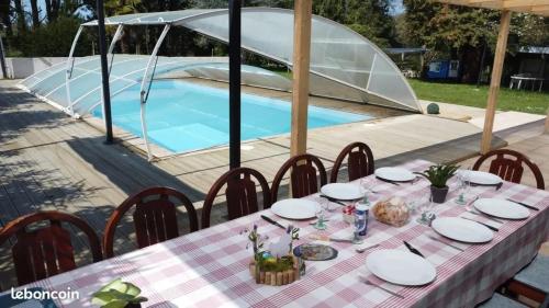 une table et des chaises devant une piscine dans l'établissement Spacieuse villa avec piscine privée à Béganne, à Béganne