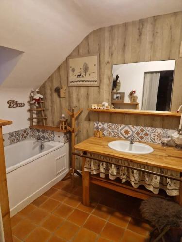 une salle de bain avec un lavabo, une baignoire et un miroir dans l'établissement Spacieuse villa avec piscine privée à Béganne, à Béganne