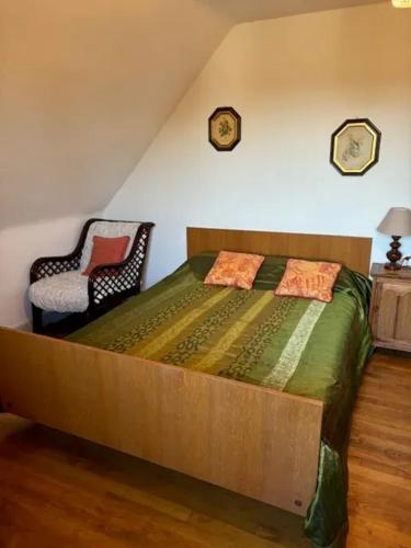 - une chambre avec un grand lit en bois et une chaise dans l'établissement Maison confortable près de Bozouls avec jardin, à Bozouls
