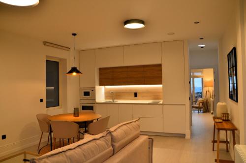 a living room and kitchen with a couch and a table at Las Terrazas de Candás in Candás