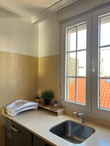 a kitchen counter with a sink and a window at La Casa de la Plaza in Cee