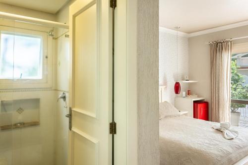 a bedroom with a bed and a window at Doce Canela - Pousada de Charme in Canela