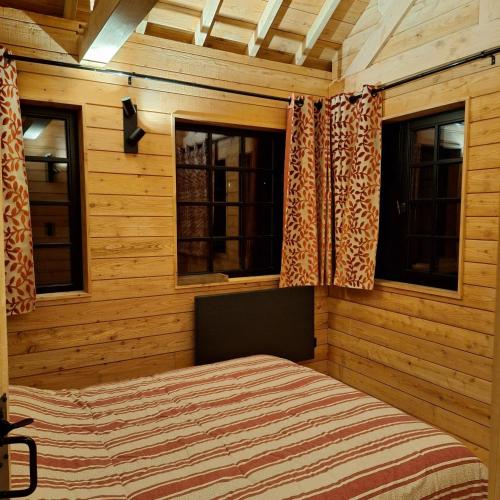 une chambre avec un lit et deux fenêtres dans l'établissement Chalet charmant à Cons-la-Grandville 50 m² avec jardin, à Cons-la-Grandville