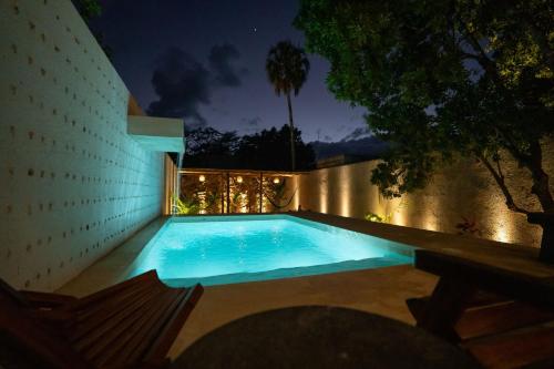 a swimming pool in a backyard at night at Wild Valladolid 3BR Oasis w Pool & Yoga Palapa in Valladolid