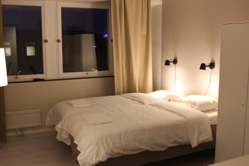 a bedroom with a bed with two lamps on it at Hotell Bromma in Stockholm