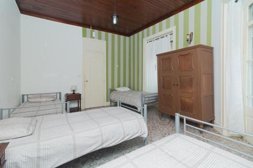 a bedroom with two beds and a dresser in it at Guet House Vila tejo in Vila Franca de Xira