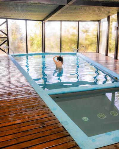 a woman in a swimming pool in a building at Hotel Parque Quilquico in Castro