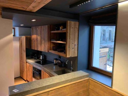 une cuisine avec un évier et une fenêtre dans l'établissement Appartement 1er Coeur de megeve, à Megève