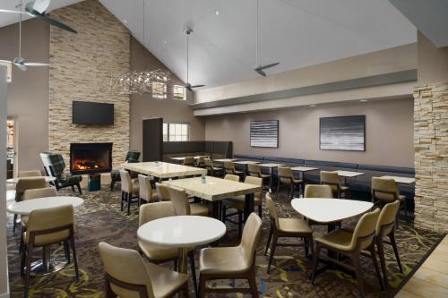 a restaurant with tables and chairs and a fireplace at Residence Inn Arlington in Arlington