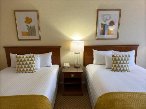 a hotel room with two beds and a lamp at The Aberdeen Dyce Hotel in Dyce