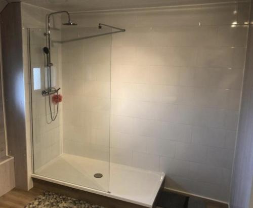 une douche avec une porte vitrée dans une salle de bain dans l'établissement La Vague, à Saint-Jouin-Bruneval