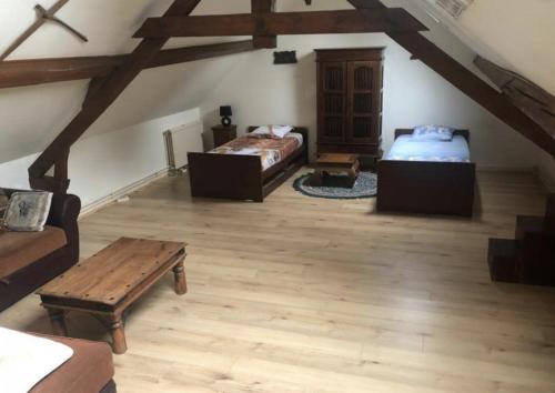 une chambre mansardée avec deux lits et une table dans l'établissement La Vague, à Saint-Jouin-Bruneval