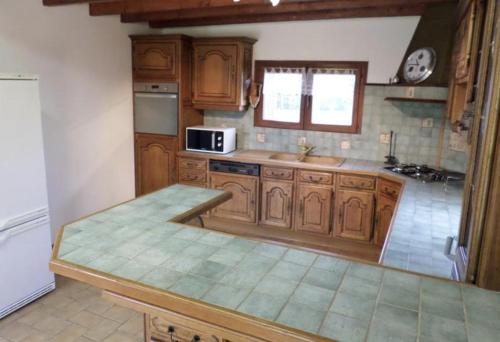 une cuisine avec des armoires en bois et un comptoir dans l'établissement La Vague, à Saint-Jouin-Bruneval