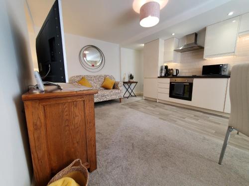 a living room with a couch and a television in it at Ipswich Town Centre Apartment 8 in Ipswich