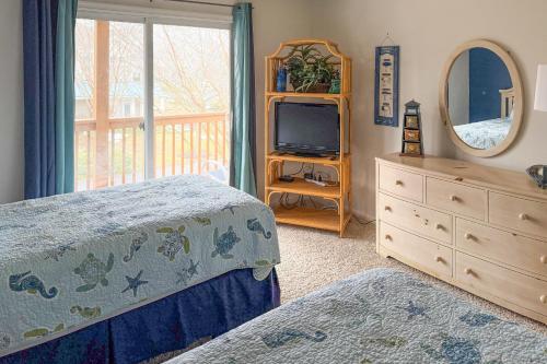 a bedroom with a bed and a dresser and a television at Sea Colony - 56192 Pine Branch in Bethany Beach