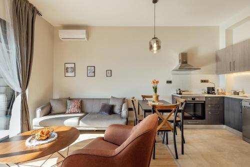 a living room and kitchen with a couch and a table at Novi Hills Residence in Španjola