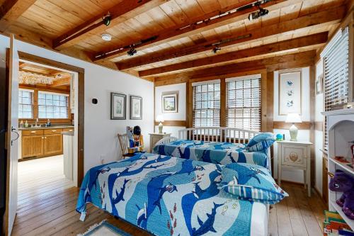 Dos camas en una habitación con techos de madera. en Great White Cape Escape, en Orleans