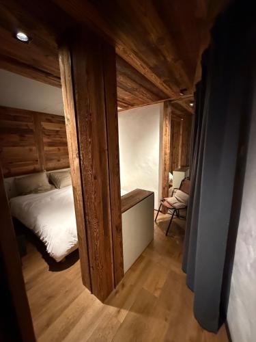 une petite chambre avec un lit et une chaise dans l'établissement Apartement RDJ CŒUR DE MEGEVE, à Megève