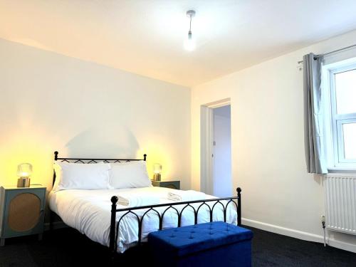 1 dormitorio con 1 cama con taburete azul en New Southampton Central House - Parking, 6 Beds, Sleeps 9 - City Centre l Cruise Terminal l Great for Contractors, Friends & Families, en Southampton