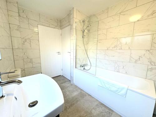 a white bathroom with a tub and a sink at New Southampton Central House - Parking, 6 Beds, Sleeps 9 - City Centre l Cruise Terminal l Great for Contractors, Friends & Families in Southampton