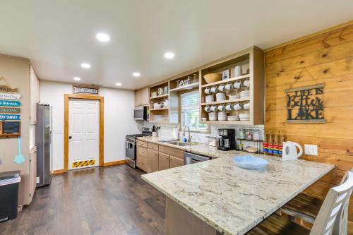 a large kitchen with wooden walls and wooden floors at Lakefront Daingerfield Retreat with Shared Dock! in Daingerfield