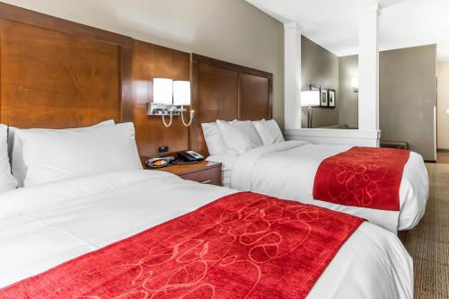 a hotel room with two beds with red blankets at Comfort Suites West Omaha in Omaha
