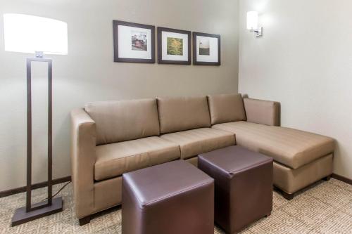 a living room with a couch and two pictures on the wall at Comfort Suites West Omaha in Omaha