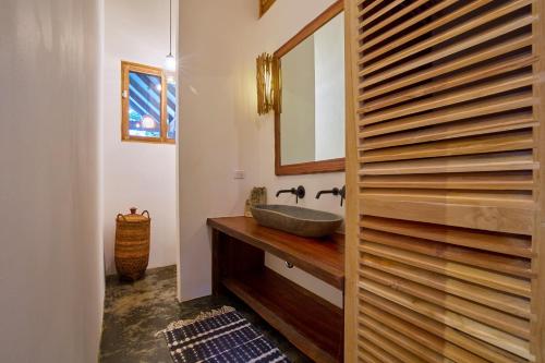 a bathroom with a sink and a mirror at Casa Ananda a Bali Inspired Home in Nosara