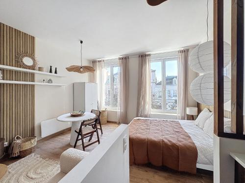 une chambre blanche avec un lit et une table dans l'établissement Le Bru t marnais, à Reims