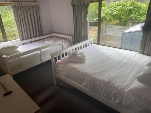 two beds in a room with a window at The Cameron Bothy in Queenstown
